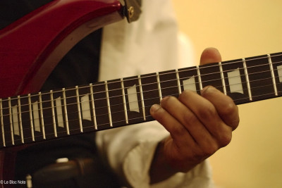 Main d'un guitariste sur le manche de son instrument