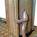 Sculpture en bois représentant un homme entrant dans un livre